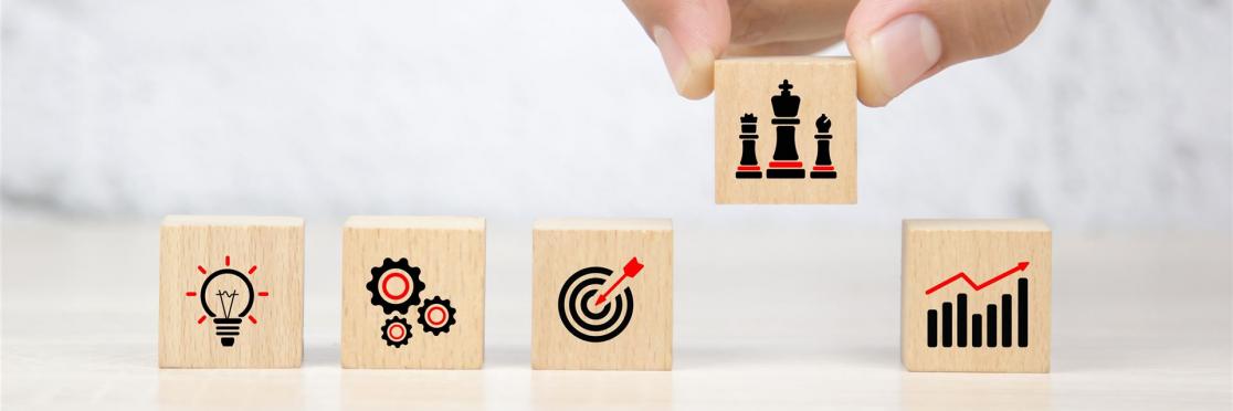 Holzbausteine mit Symbolen für Idee, Prozess, Ziel, Strategie und Wachstum – symbolisieren die Entwicklung und Umsetzung einer erfolgreichen HR-Strategie