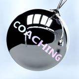 Silberne Pendelkugeln mit den Wörtern 'Coaching' und 'Change' symbolisieren Impulse für Veränderung durch professionelles Executive Coaching