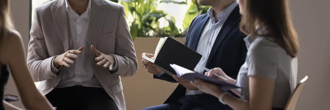 Führungskraft im Gespräch mit einem kleinen Team während einer Coaching-Sitzung, symbolisiert vertrauensvolle Kommunikation und persönliche Weiterentwicklung im Leadership Coaching